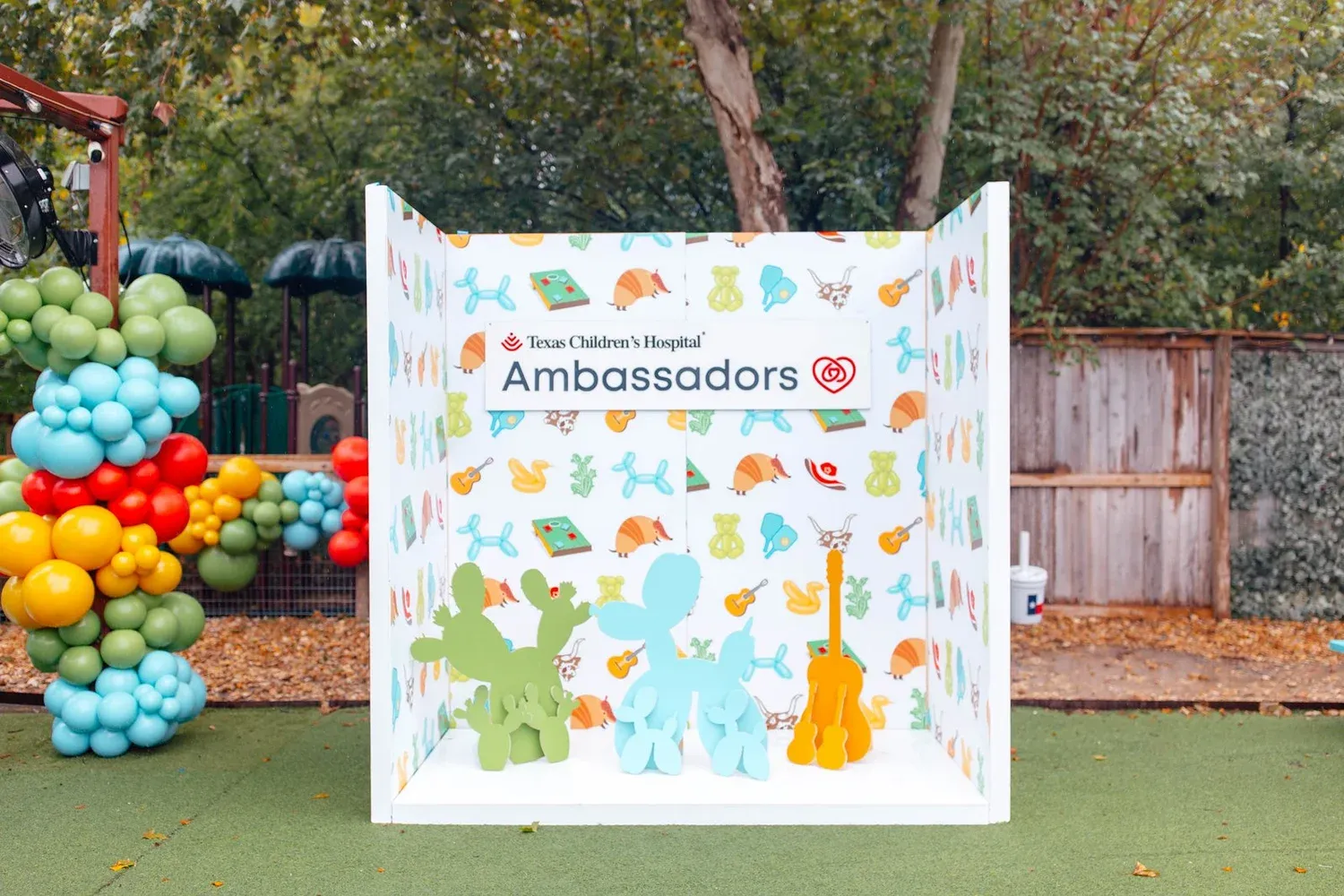Branded photo booth with Austin themed pattern and 3D cactus, balloon dog and guitar cutouts