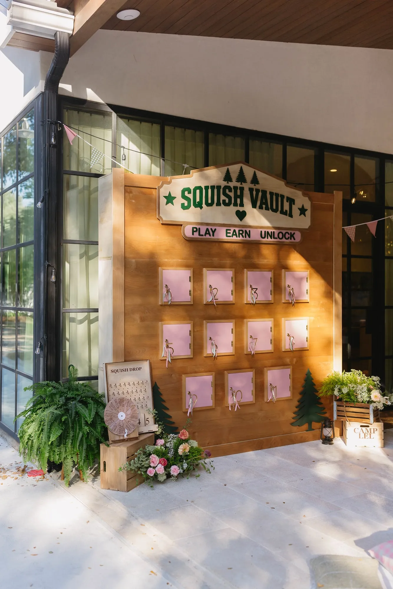 Custom camp themed game wall with lockers, a prize spinner and florals