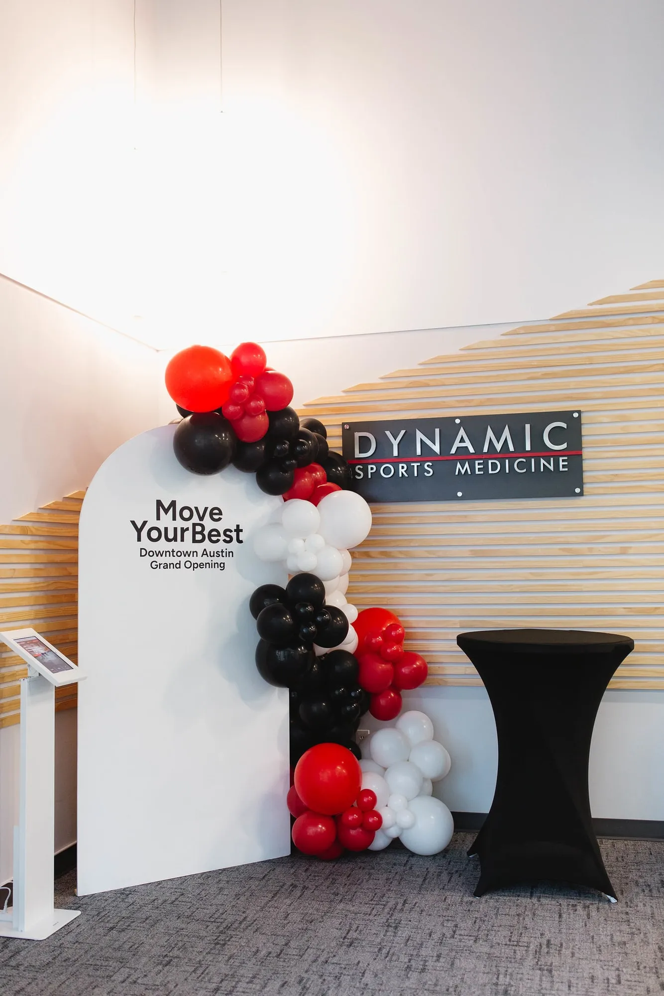 Red, black and white balloon garland on a Move Your Best arch for the Dynamic Sports Medicine downtown Austin grand opening