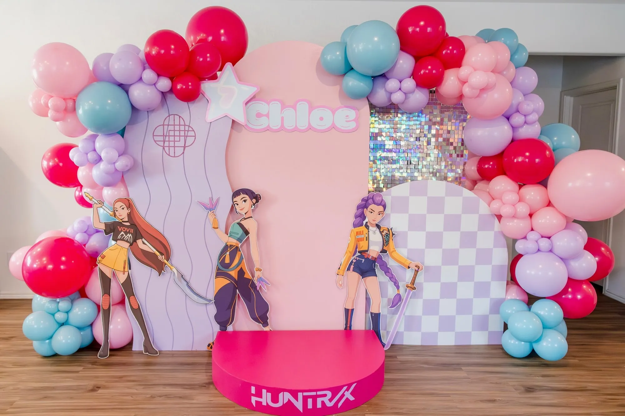 K-pop themed seventh birthday with pink and lilac panels, shimmer wall, character cutouts, a mini stage and bright balloon garland