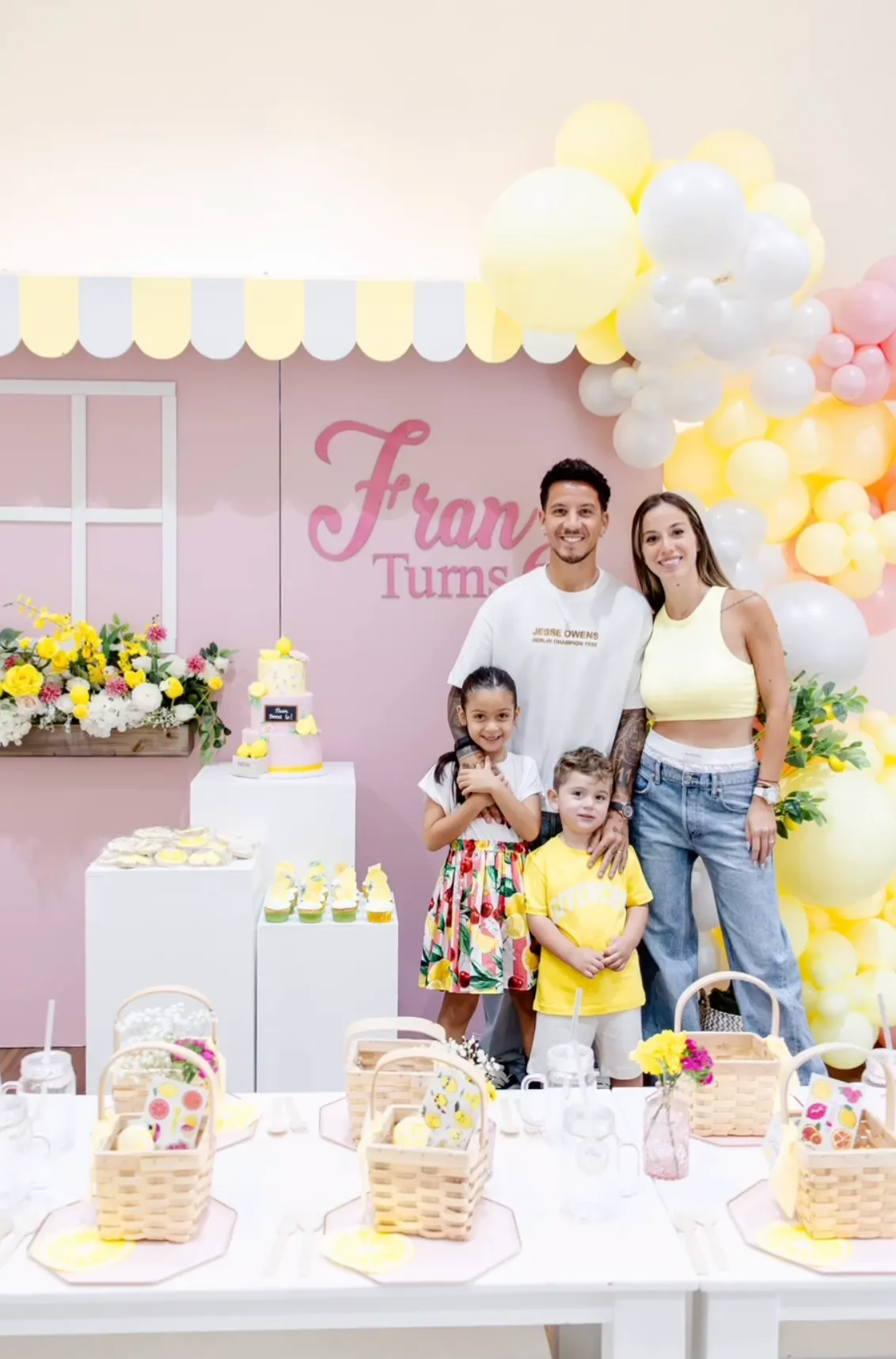 Lemonade stand birthday backdrop with scalloped awning and yellow and white balloon garland