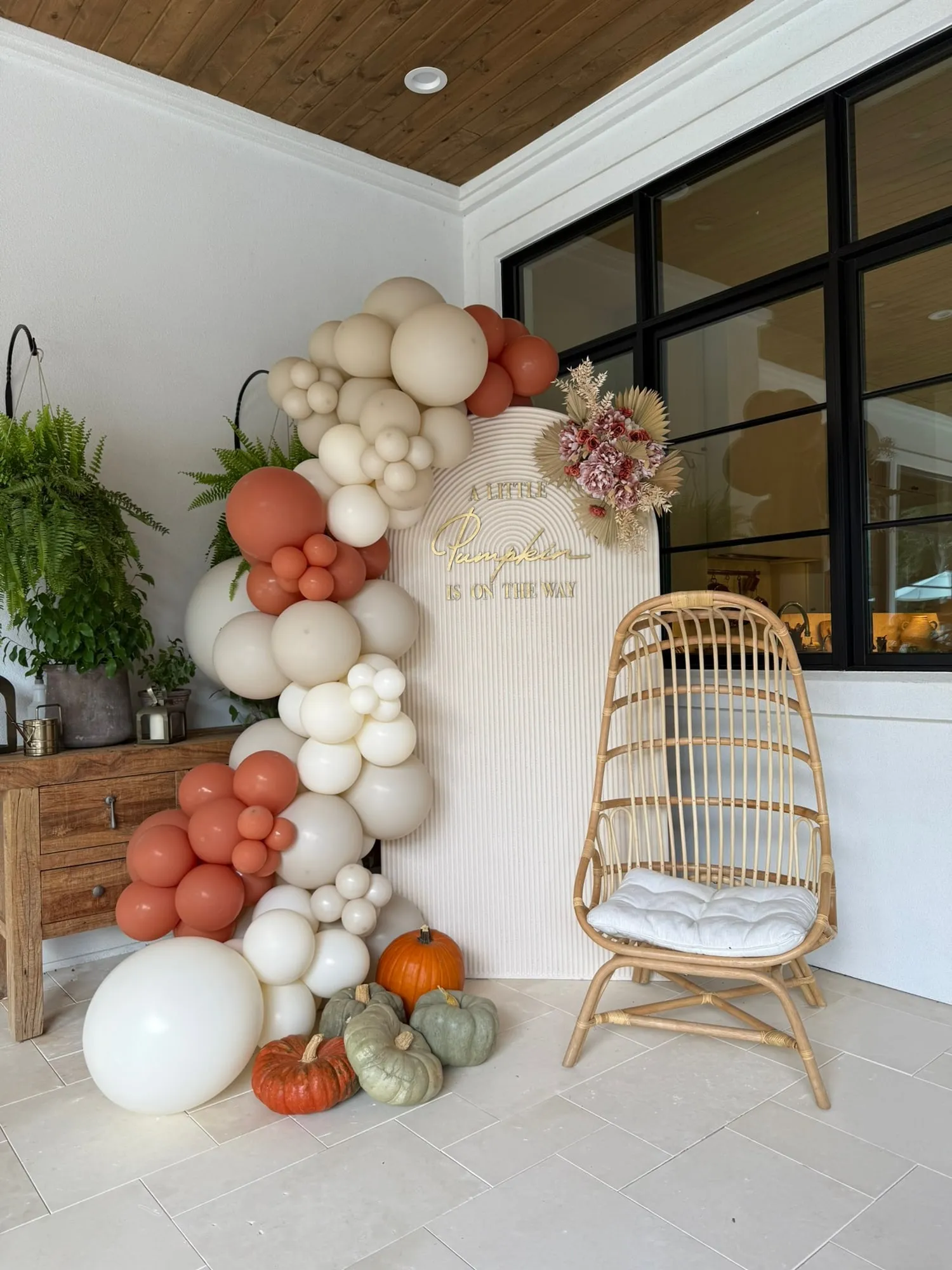Little Pumpkin baby shower with a cream fluted arch, terracotta and cream balloon garland, dried florals and pumpkins